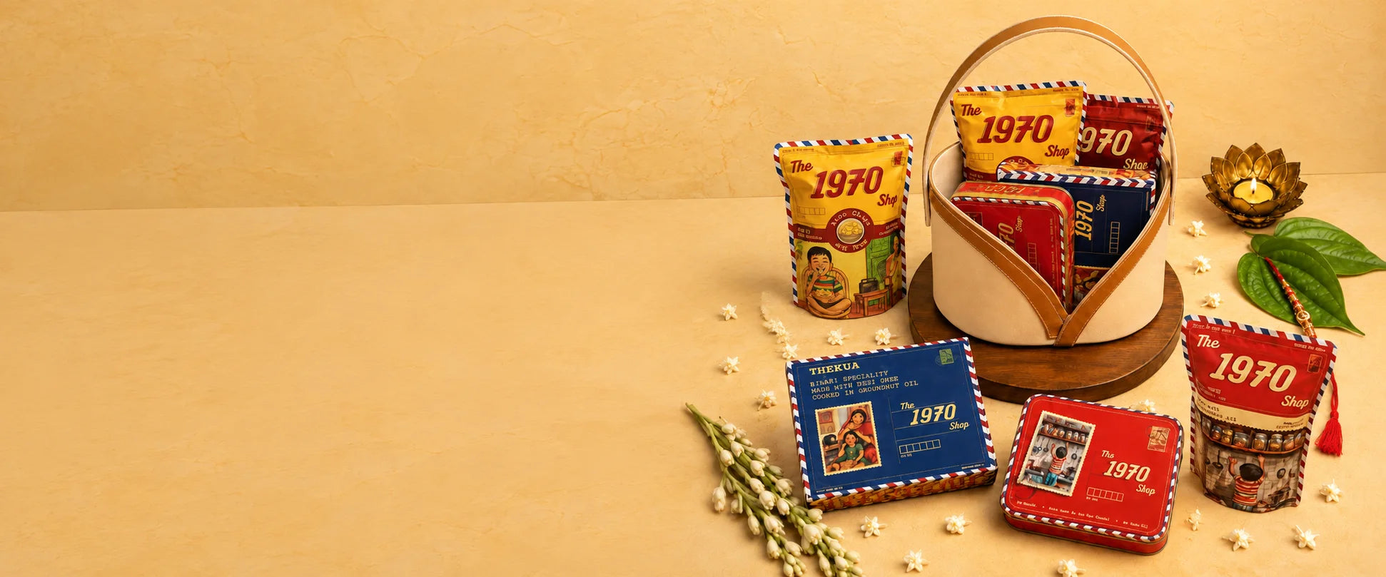 A 1970 Shop gift basket with tins and snack pouches, a diya and jasmine